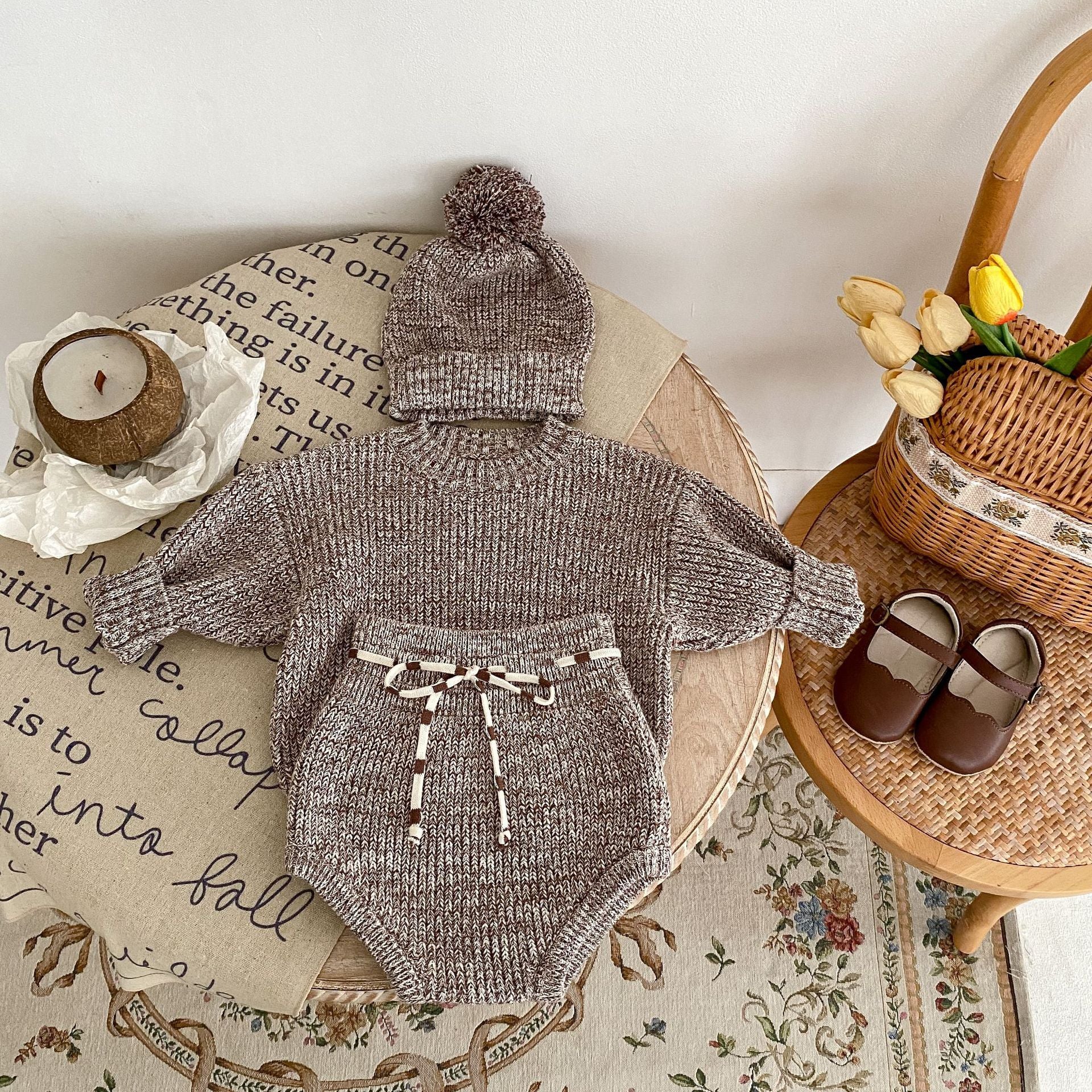 Baby girl wearing dark brown knit 3-piece set with long sleeve top, shorts and removable hood