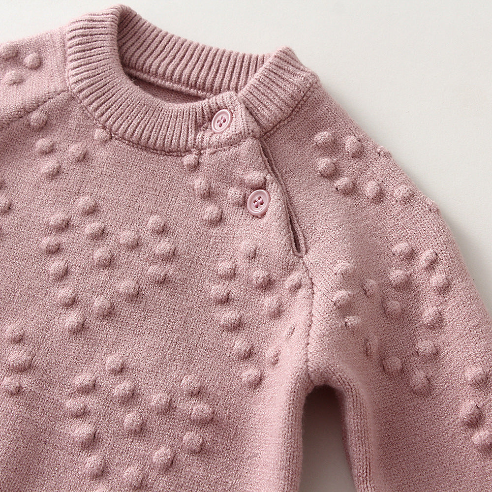 Pink knitted sweater with textured pattern on a light background