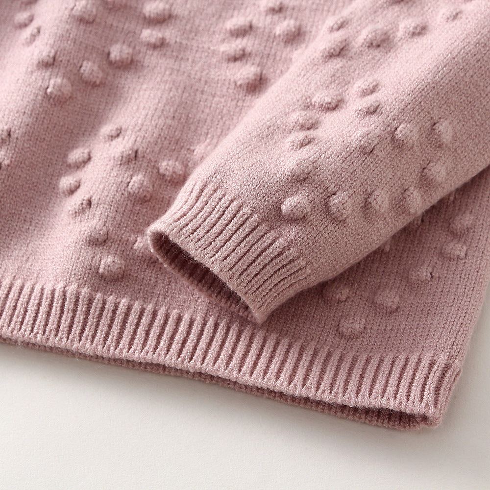 Pink sweater with textured pattern on a light background