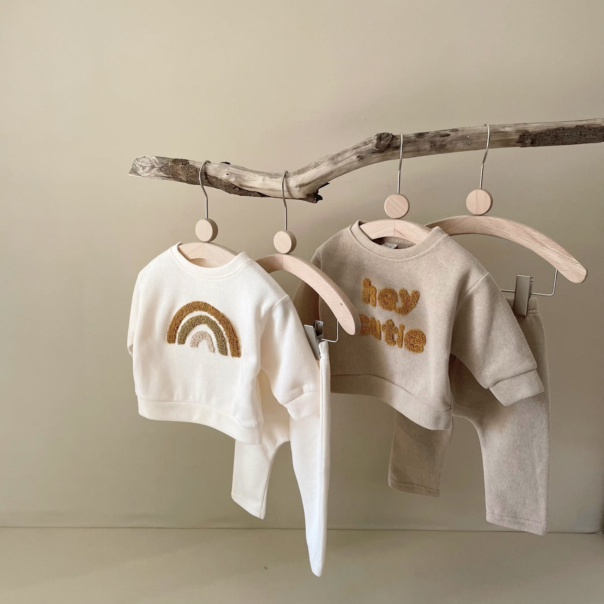 Baby wearing alphabet embroidered sweater and pants set in creamy-white color